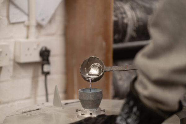 Molten metal being poured into a mould in the Glasgow workshop