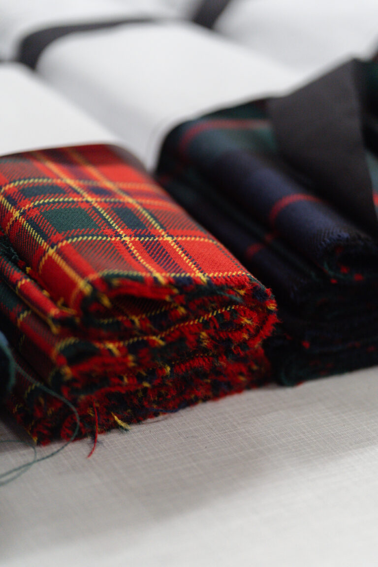 Folded red tartan and paper patterns in the Glasgow workshop