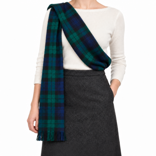 Black Watch tartan sash draped across an ivory top, with fringed end